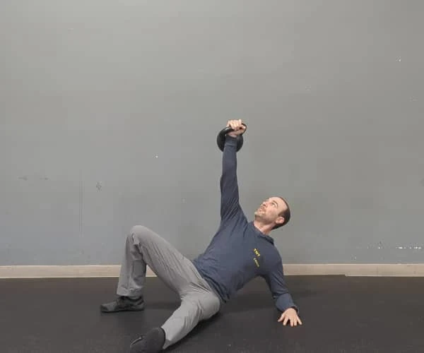 Coach Ryan demonstrates braced abs near the bottom of the getup.