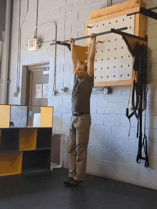 Coach Ryan demonstrates a hollow hang that immediately leads to a pullup.