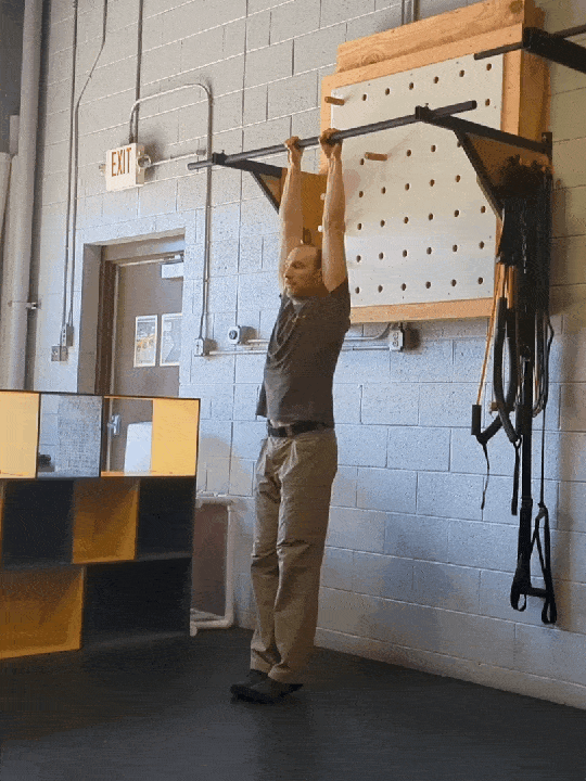 Coach Ryan demonstrates the hollow hang—a hollow position hanging from a bar.