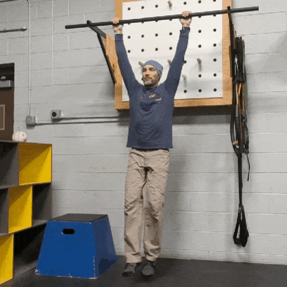Coach Ryan demonstrates "Skin the Cat" on a pullup bar.